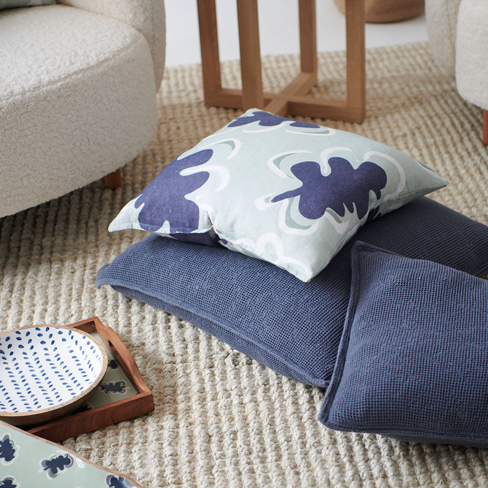 100% linen cushion in a sea mist and navy leaf abstract pattern and a contrast stitch feature