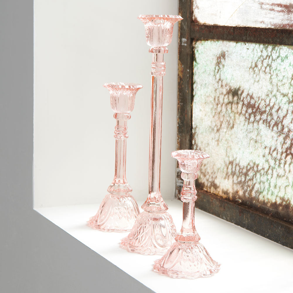 glass candlestick holders in multiple sizes in pink