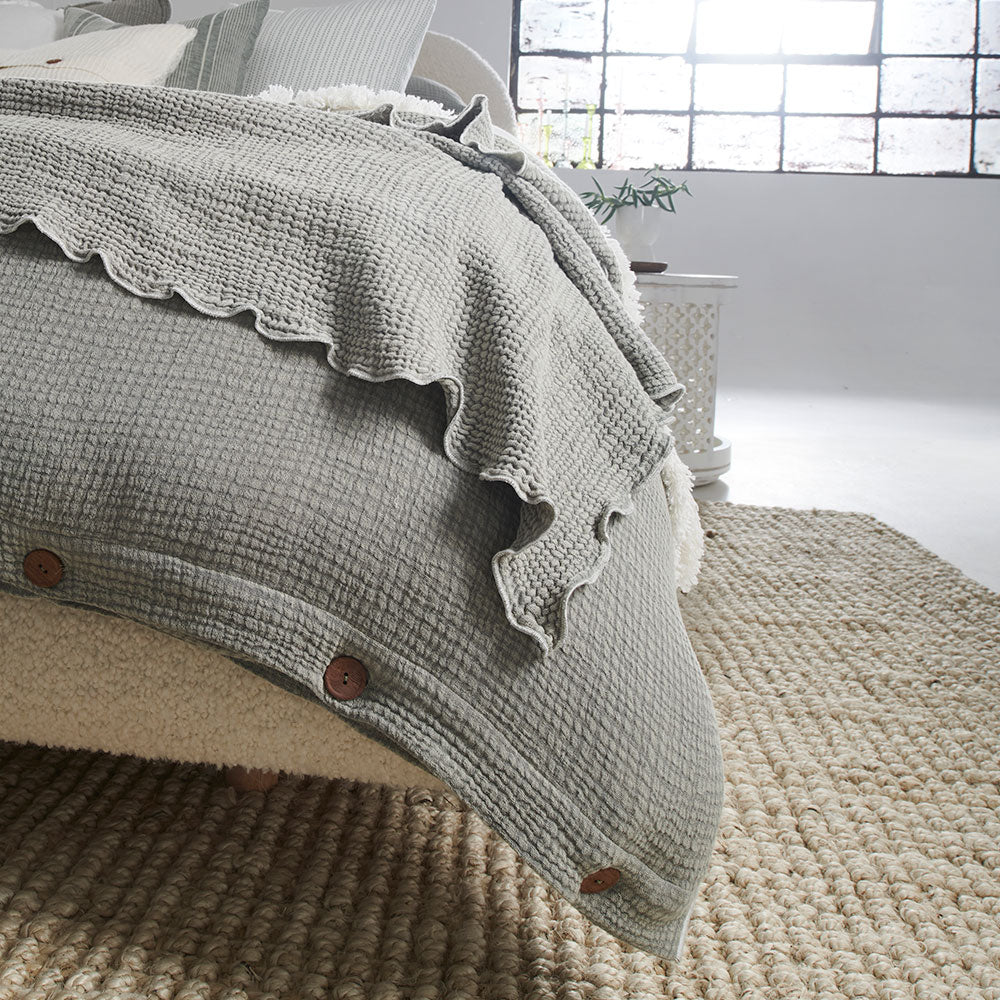pistachio coloured duvet set with contrast stitching, lettuce edge and wooden button feature