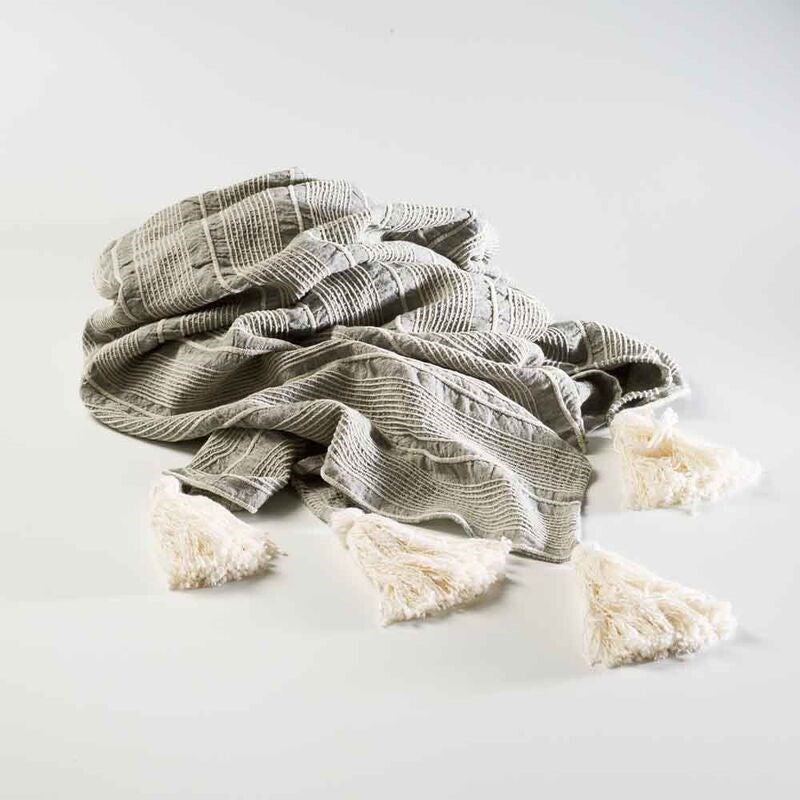 pistachio linen throw with a white stripe feature and tassels on the corners