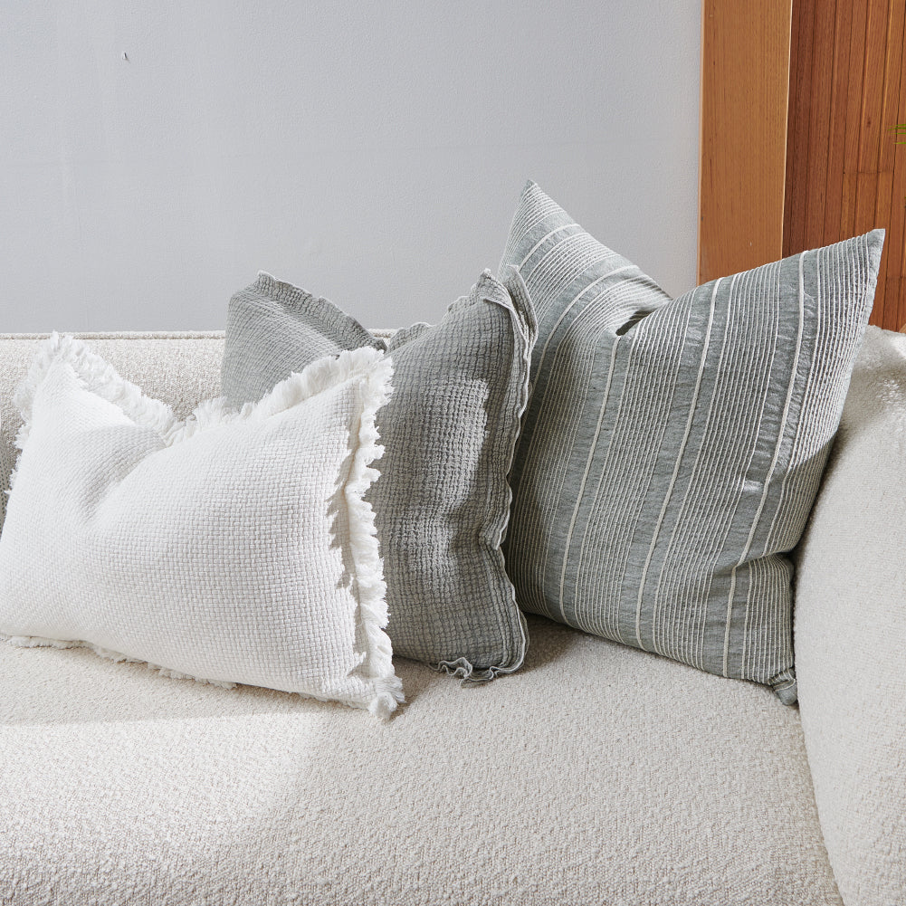 pistachio coloured cushion in a soft fabric with a double flange design and contrast stitching detail