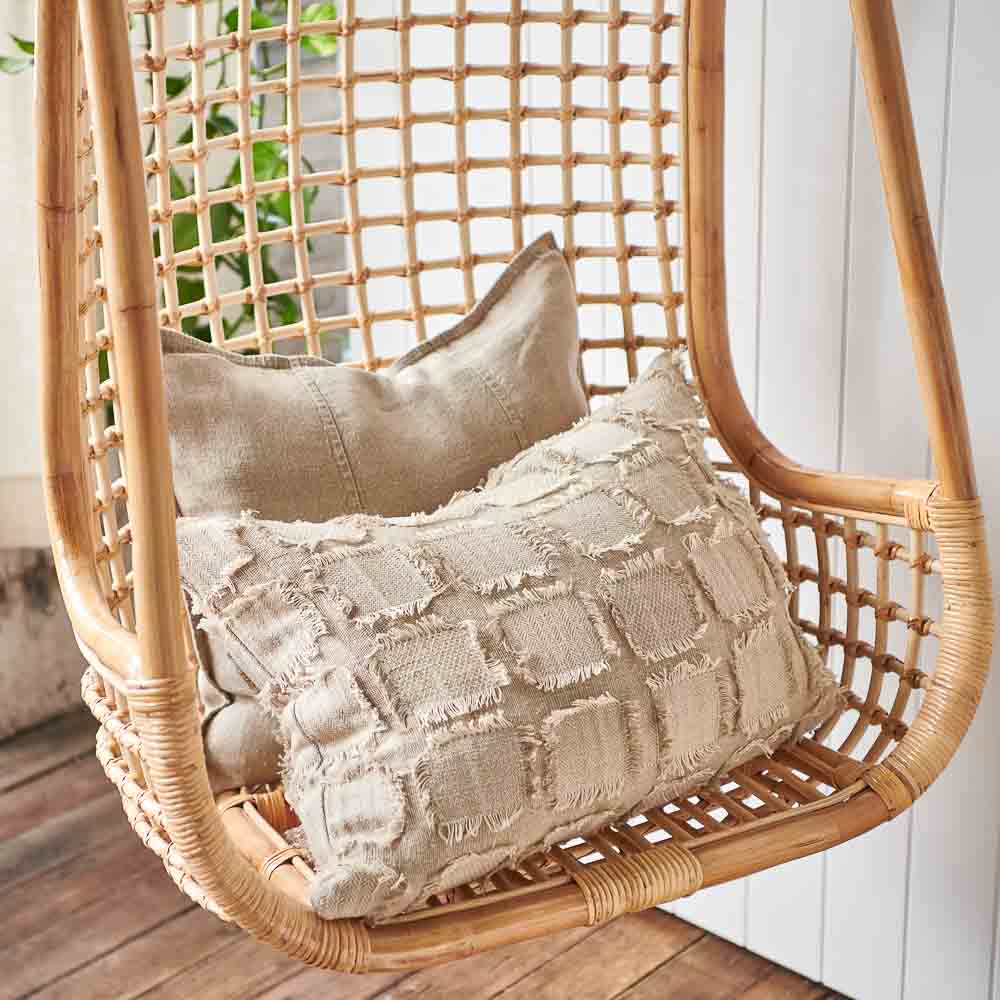 Bedu Cushion and Luca Linen Cushion in natural sitting on a hanging chair
