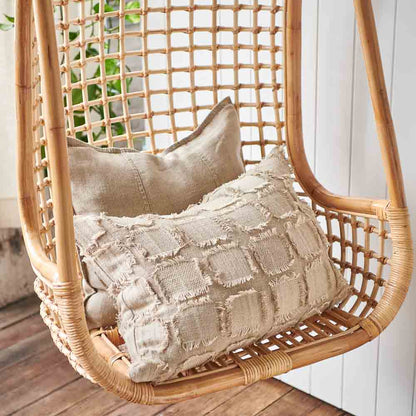 Bedu Cushion and Luca Linen Cushion in natural sitting on a hanging chair