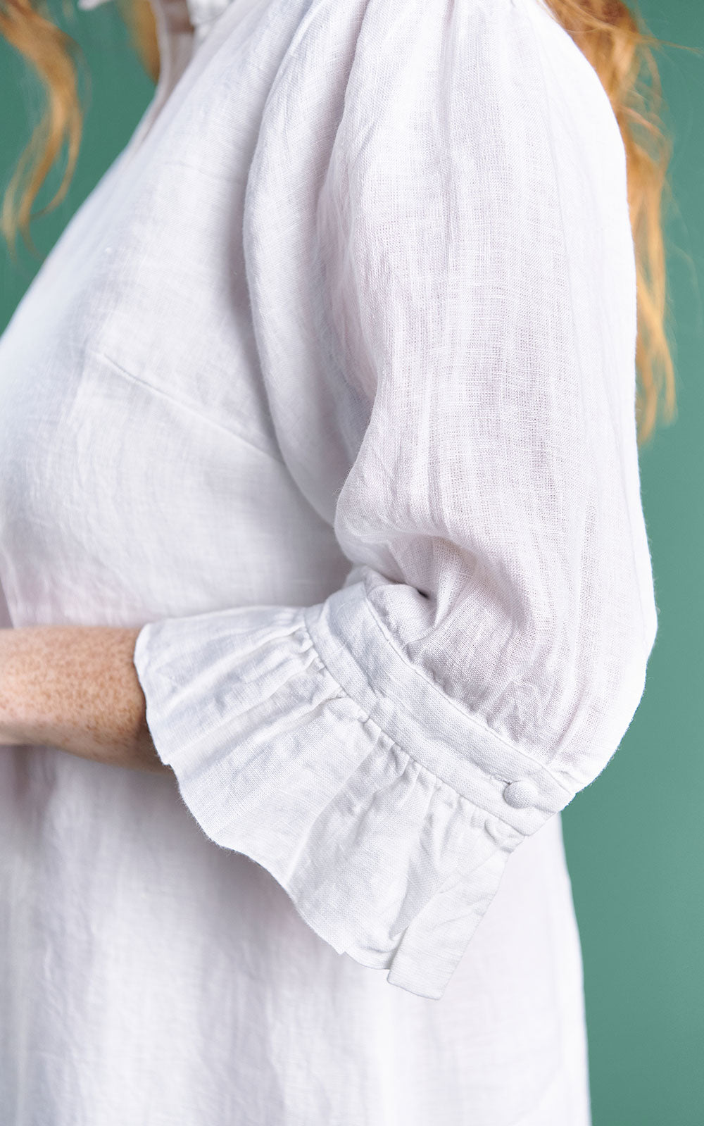 white linen mini dress with high neck frill and sleeves