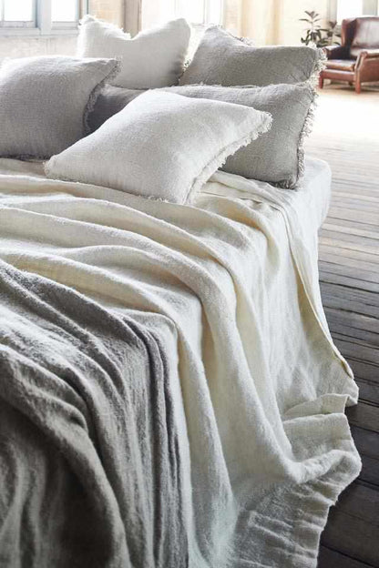 White Bedouin Oversized Linen Bed Throw layered with Bedouin Linen Cushions  on bed