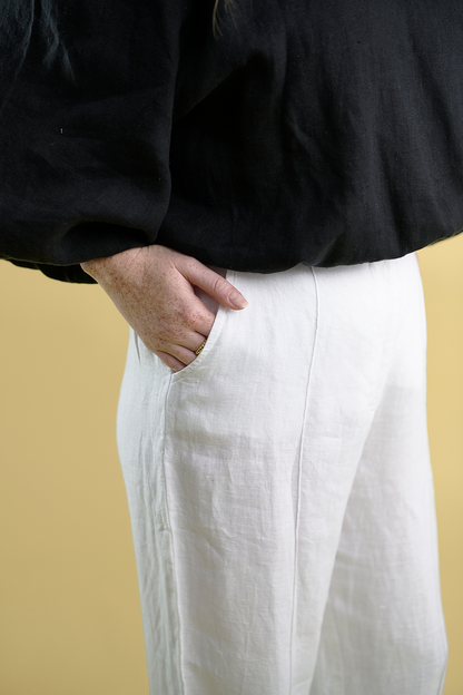 tailored linen pants with wooden button and single pleat down the front in white