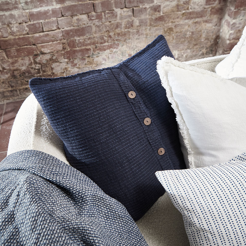 navy blue ribbed linen cushion with wooden button closure feature and frayed edging