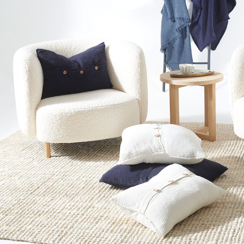 navy blue ribbed linen cushion with wooden button closure feature and frayed edging