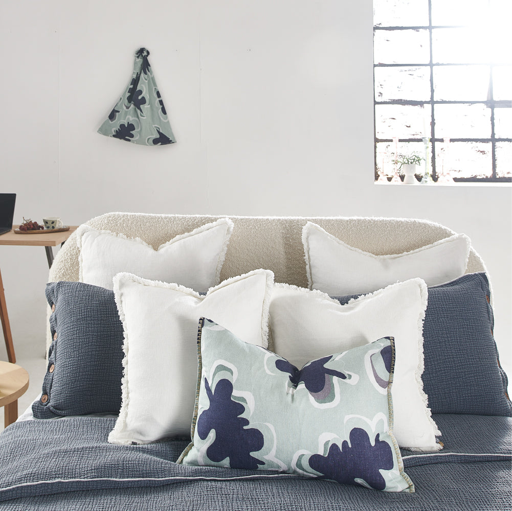 100% linen cushion in a sea mist and navy leaf abstract pattern and a contrast stitch feature